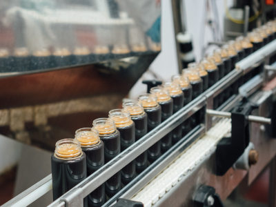 Production line with filled jars containing cold coffee.