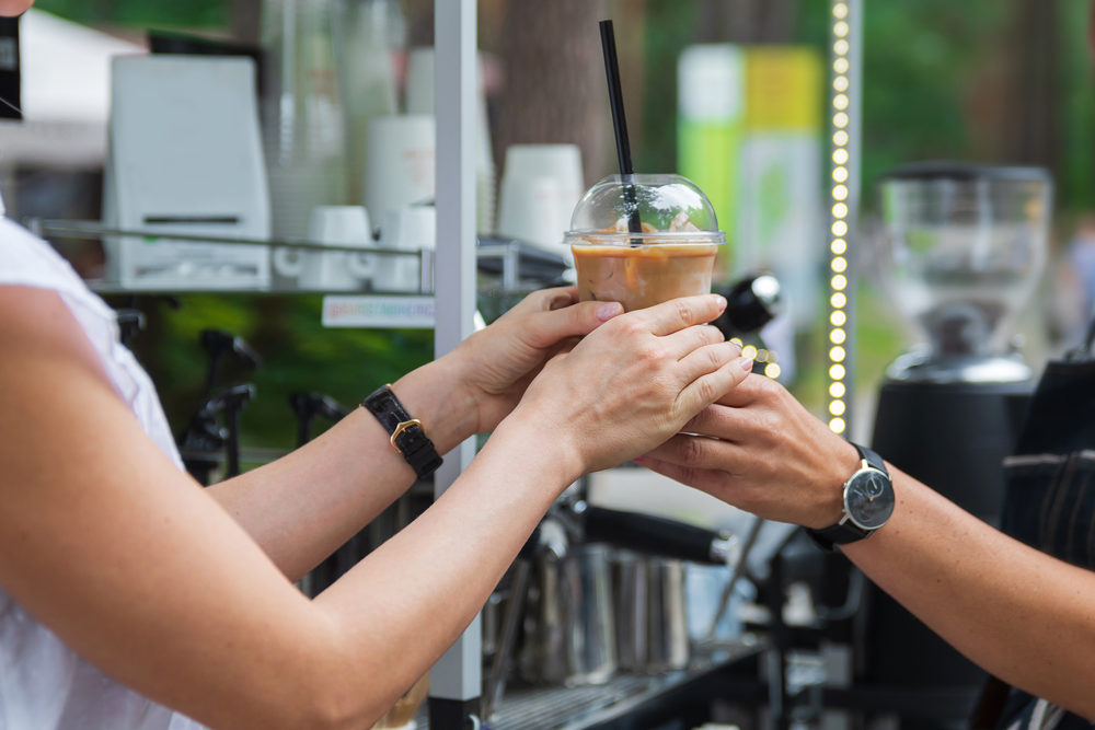Barista handing out a latte to the client