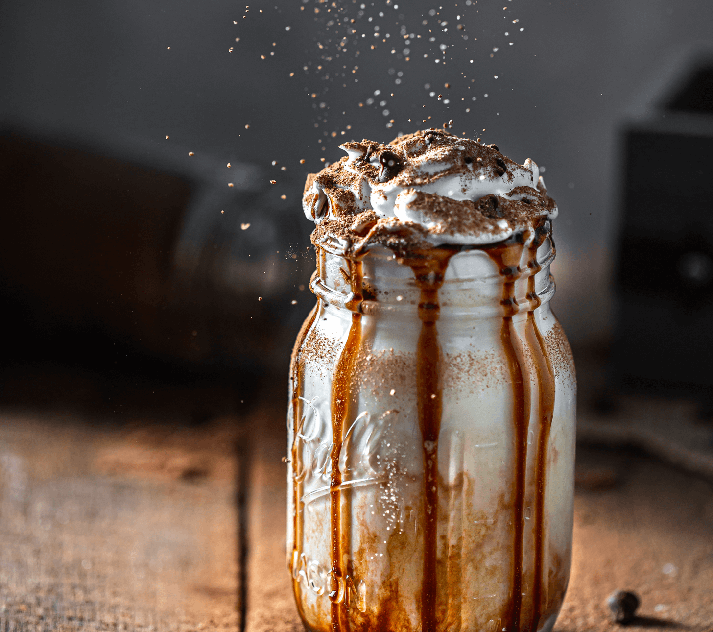 A glass jar filled with liquid sits on top of a wooden table